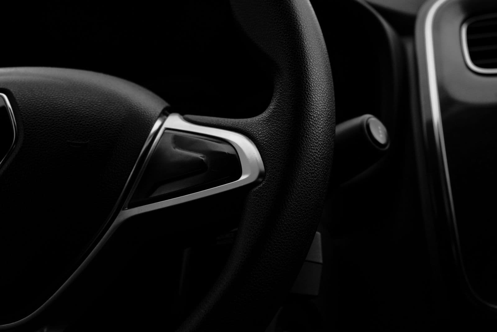 Intérieur automobile sombre, volant et planche de bord